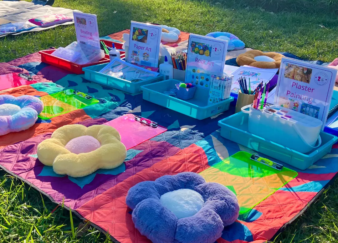 children doing craft activities in the park with Aunty Em