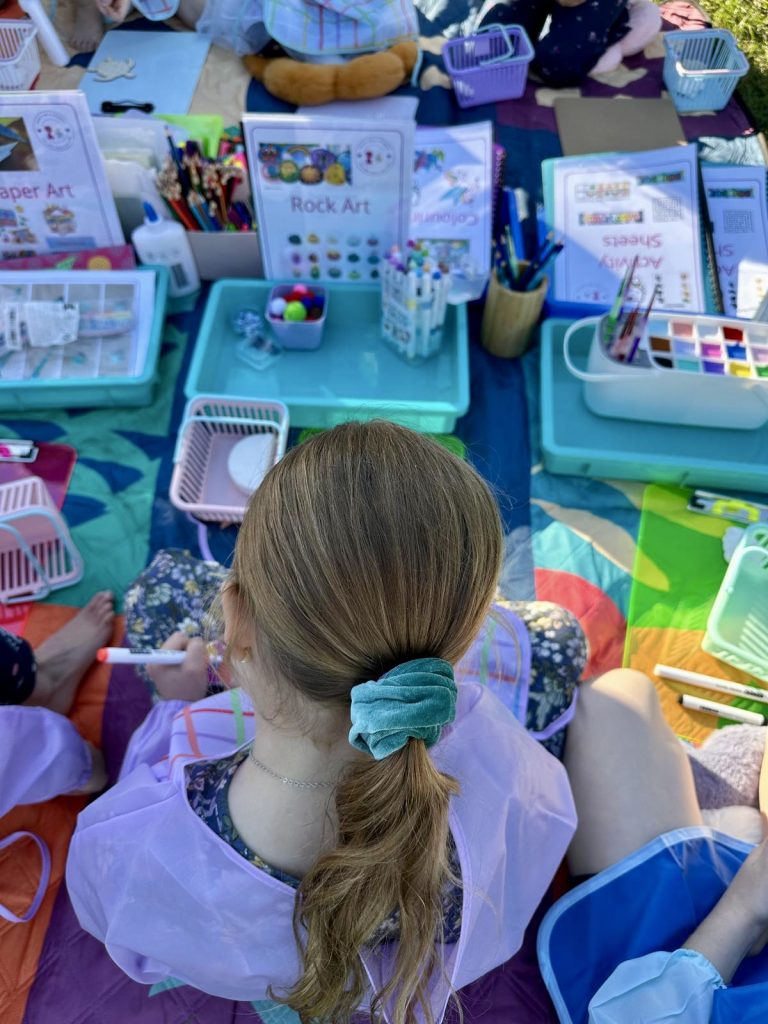 children doing craft activities in the park with Aunty Em