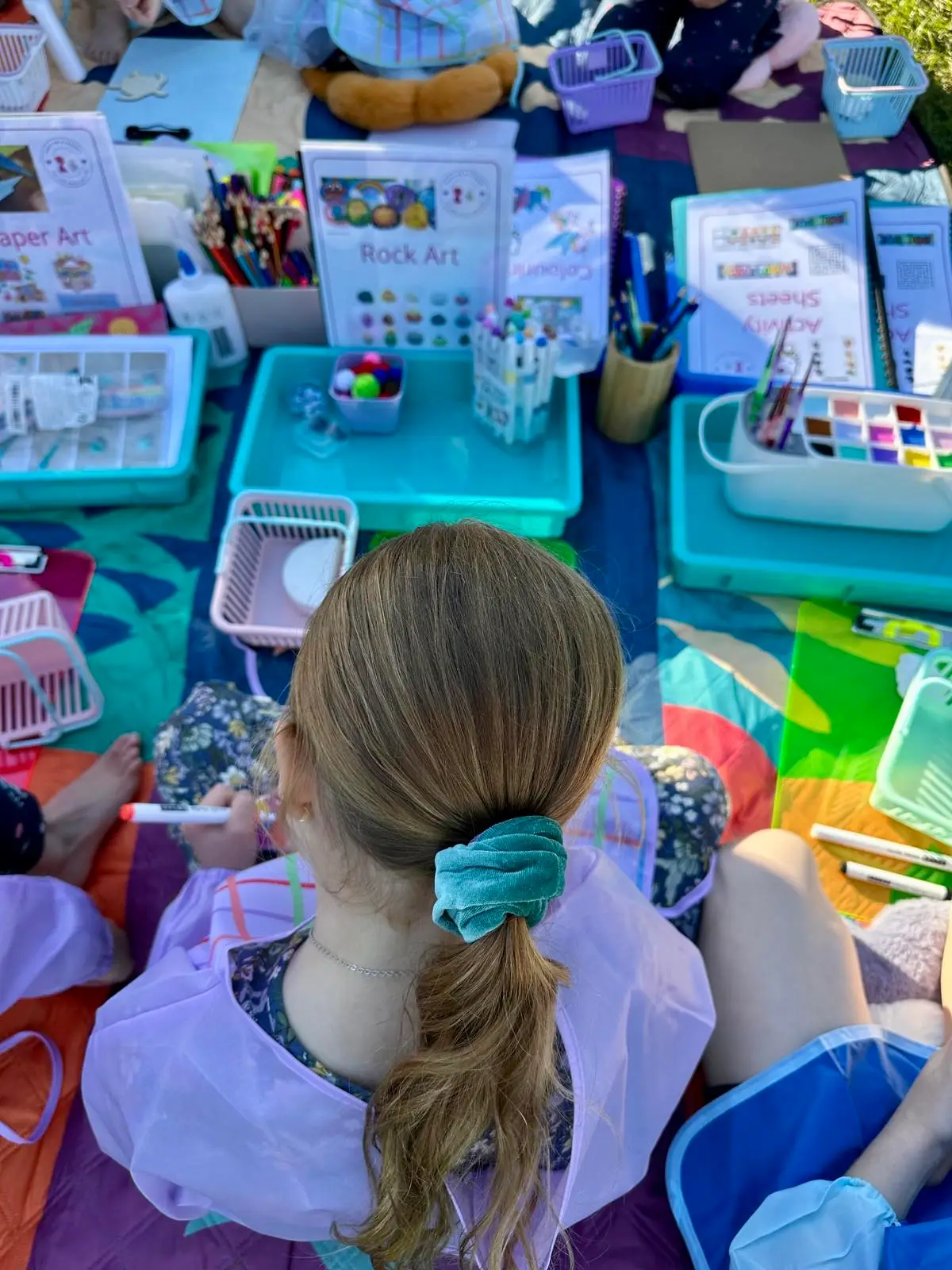 children doing craft activities in the park with Aunty Em