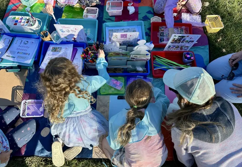 children doing craft activities in the park with Aunty Em