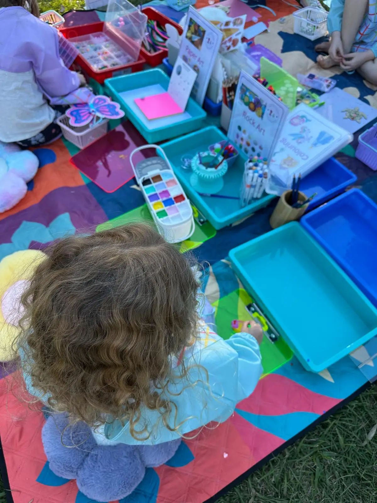 children doing craft activities in the park with Aunty Em